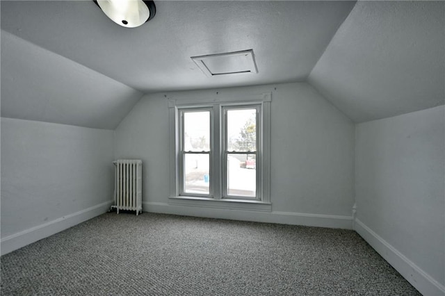 bonus room featuring lofted ceiling, carpet floors, radiator heating unit, and a textured ceiling