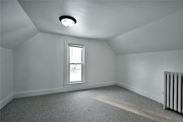 bonus room with vaulted ceiling, carpet floors, and radiator heating unit