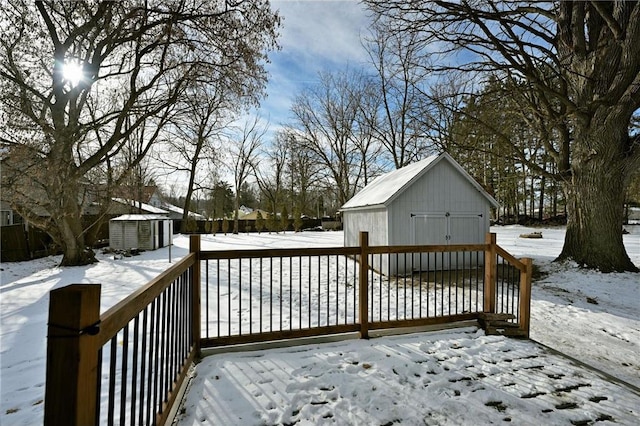 snow covered deck with a storage shed