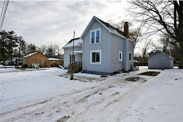 snow covered property featuring a storage shed