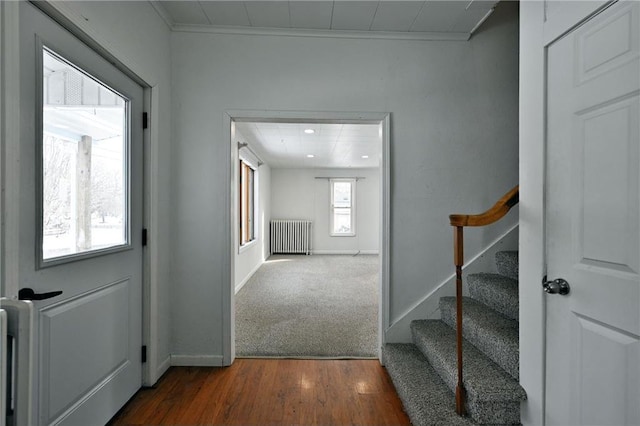 foyer entrance with dark hardwood / wood-style flooring and radiator heating unit