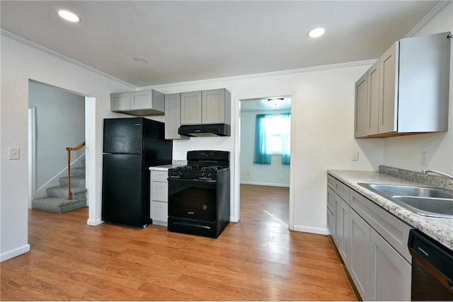 kitchen with gray cabinets, sink, ornamental molding, black appliances, and light hardwood / wood-style flooring