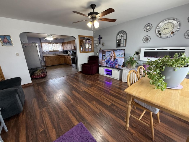 living room featuring ceiling fan and dark hardwood / wood-style flooring