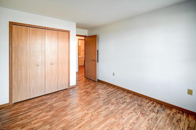 unfurnished bedroom featuring light hardwood / wood-style floors and a closet