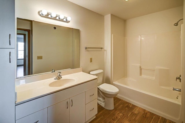 full bathroom with  shower combination, toilet, hardwood / wood-style floors, and vanity