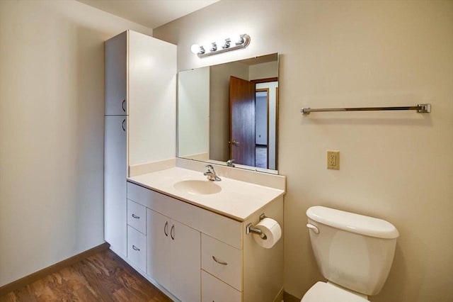 bathroom with vanity, toilet, and wood-type flooring