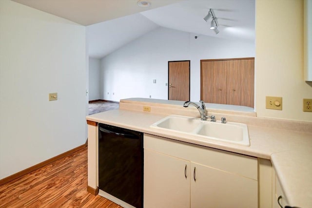 kitchen featuring lofted ceiling, sink, rail lighting, black dishwasher, and light wood-type flooring