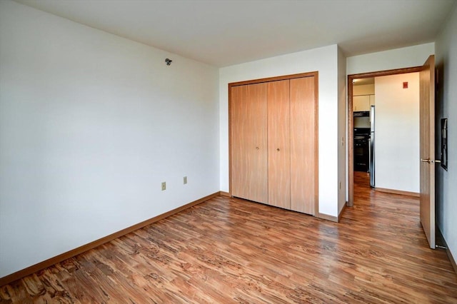 unfurnished bedroom with hardwood / wood-style flooring and a closet