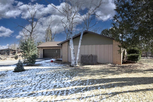 view of snowy exterior with a garage