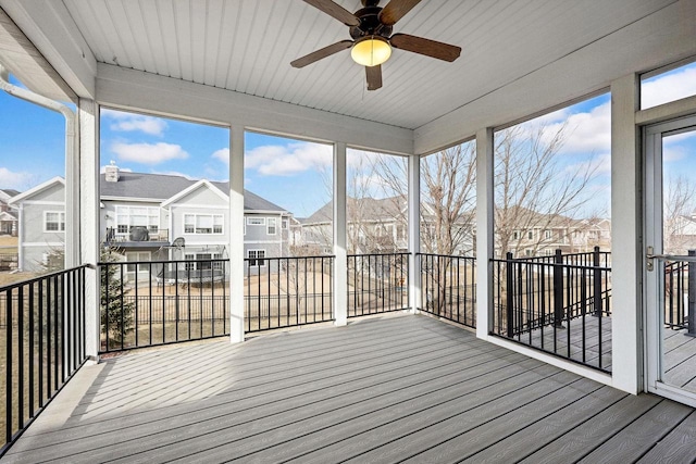 unfurnished sunroom featuring ceiling fan