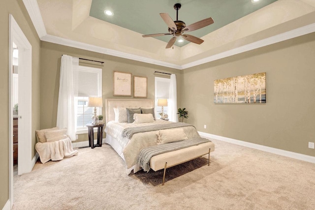 carpeted bedroom with ornamental molding, a raised ceiling, and ceiling fan