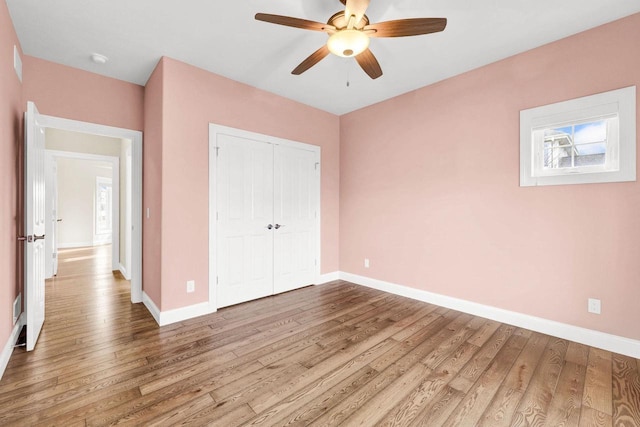 unfurnished bedroom with ceiling fan, hardwood / wood-style floors, and a closet