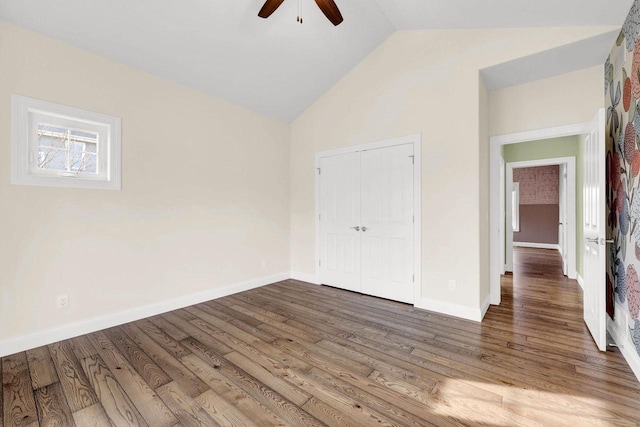 unfurnished bedroom with vaulted ceiling, hardwood / wood-style floors, ceiling fan, and a closet