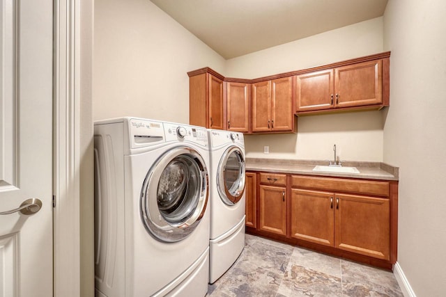 laundry room featuring cabinets, independent washer and dryer, and sink