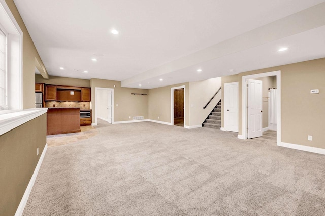 unfurnished living room featuring light carpet