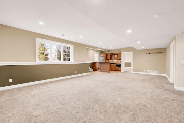 unfurnished living room featuring light carpet