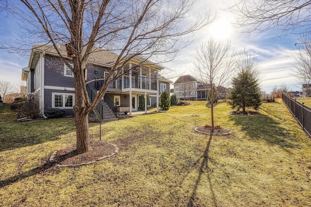 rear view of property with a yard and a sunroom