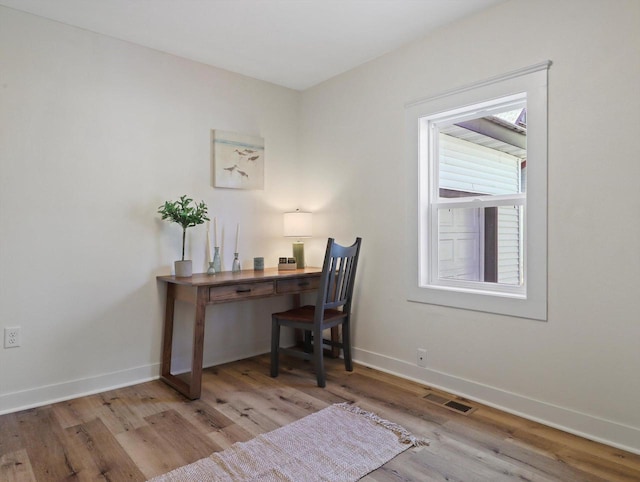 home office with light hardwood / wood-style floors