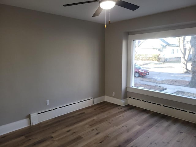 empty room featuring ceiling fan, a baseboard radiator, and wood-type flooring