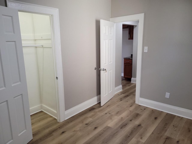 unfurnished bedroom featuring light hardwood / wood-style floors and a closet