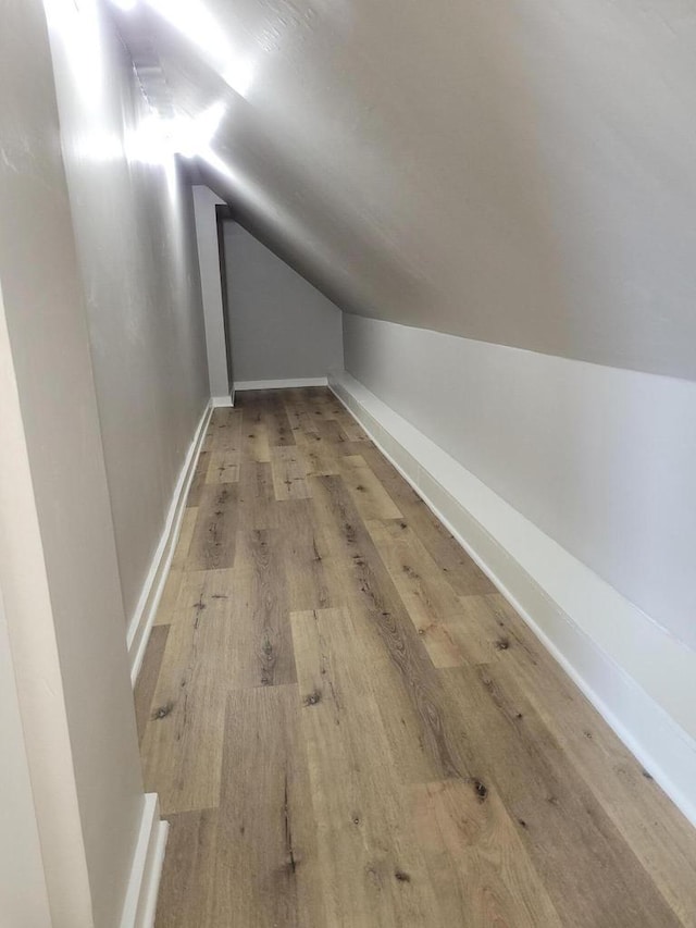 additional living space featuring lofted ceiling and hardwood / wood-style floors