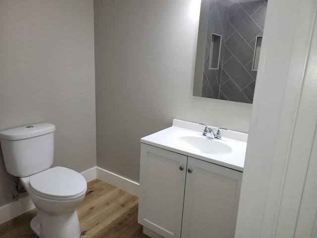 bathroom featuring vanity, wood-type flooring, and toilet