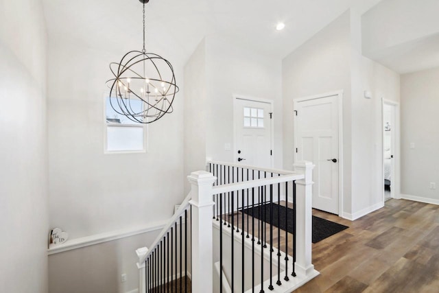 hallway with hardwood / wood-style floors, a notable chandelier, and a healthy amount of sunlight