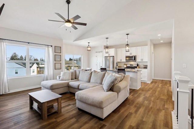 living room with high vaulted ceiling, dark hardwood / wood-style floors, sink, and ceiling fan