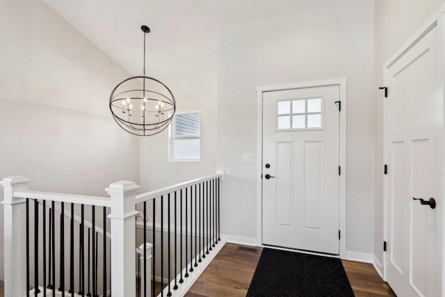 foyer featuring dark hardwood / wood-style flooring, a wealth of natural light, and a chandelier