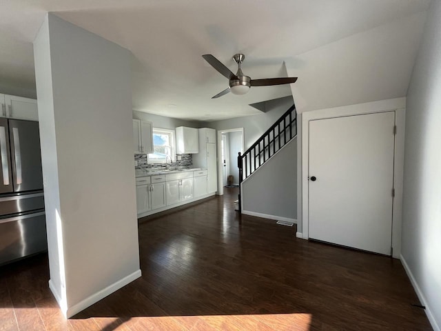 unfurnished living room featuring sink, dark wood-type flooring, and ceiling fan