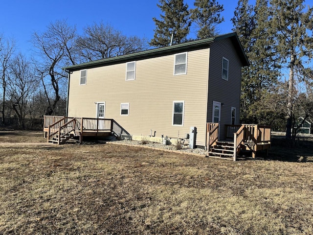 rear view of property featuring a yard and a deck