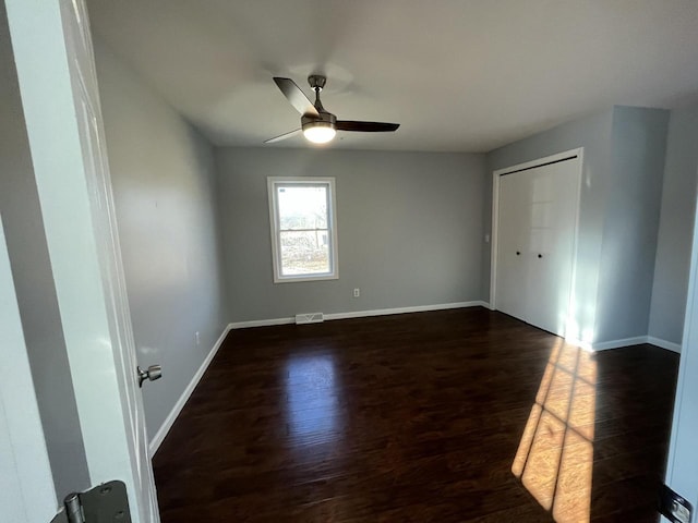 spare room with dark hardwood / wood-style floors and ceiling fan