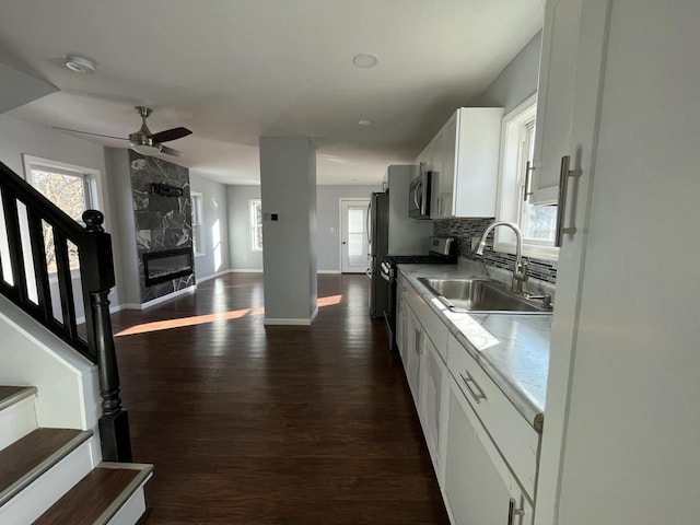 kitchen featuring sink, decorative backsplash, white cabinets, and appliances with stainless steel finishes