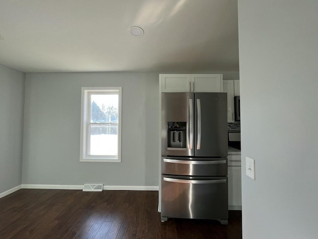 kitchen featuring white cabinetry, stainless steel fridge, and dark hardwood / wood-style flooring