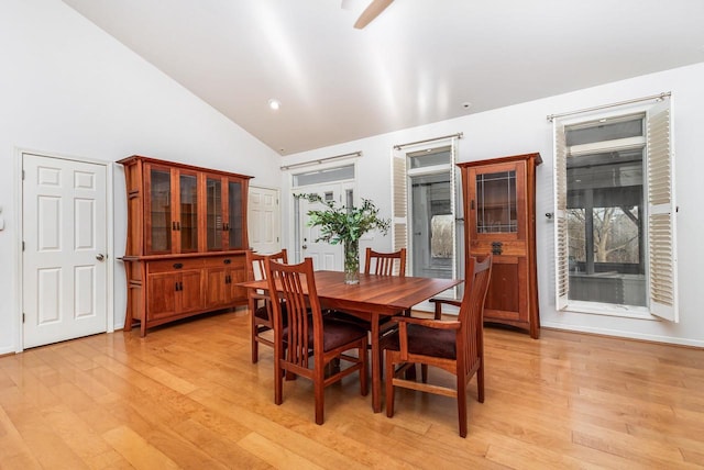 dining area with light hardwood / wood-style flooring and high vaulted ceiling