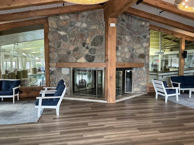 interior space featuring a stone fireplace, lofted ceiling with beams, and hardwood / wood-style flooring