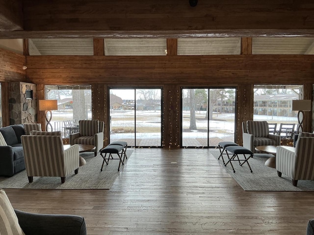 living room with hardwood / wood-style flooring, a healthy amount of sunlight, and wood walls