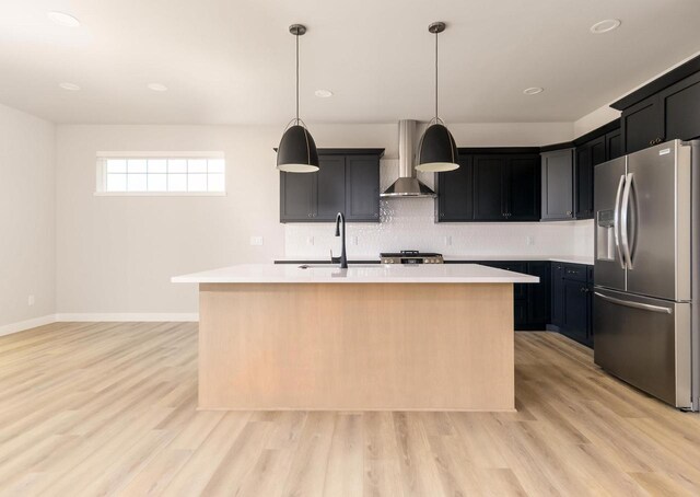 600 E Verleen Ave, Waunakee, WI 53597 - kitchen featuring stainless steel fridge with ice dispenser, a sink, wall chimney range hood, light countertops, and light wood-style flooring