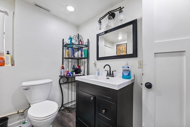 bathroom with wood-type flooring, vanity, and toilet