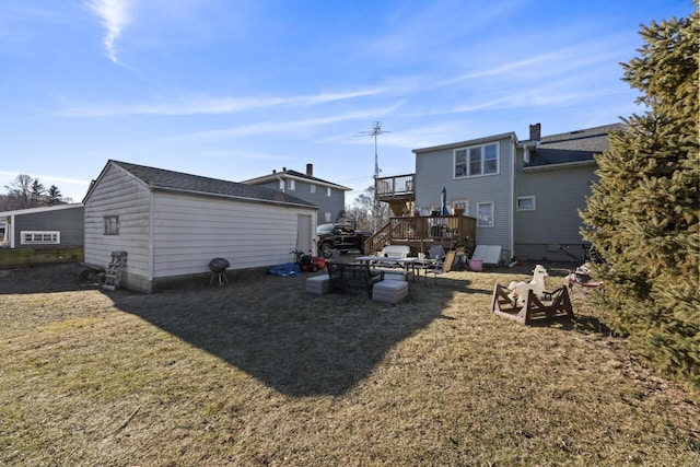 rear view of house featuring a wooden deck and a yard