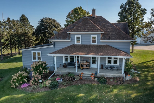 rear view of property with a patio and a lawn