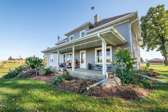 rear view of house with a yard and covered porch