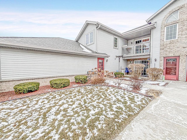 snow covered property featuring a balcony