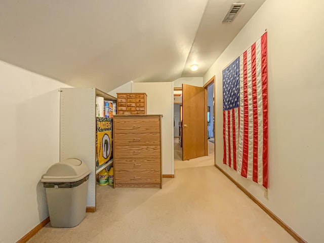 hall featuring lofted ceiling and light carpet