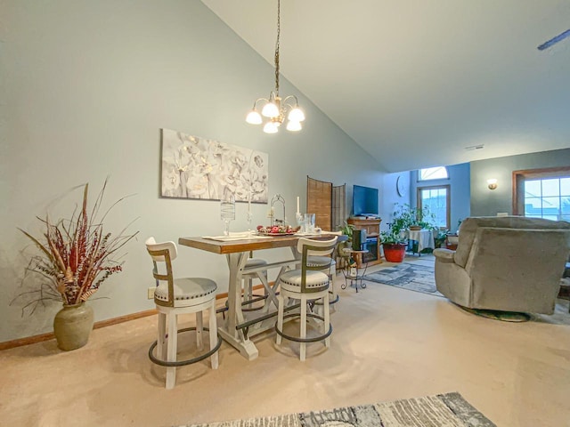 dining space featuring carpet, an inviting chandelier, and high vaulted ceiling