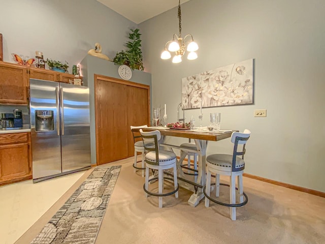 carpeted dining area featuring a high ceiling and a chandelier