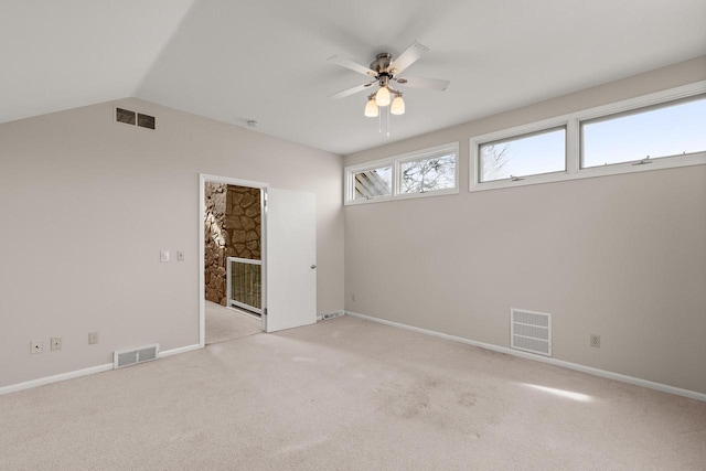 spare room featuring vaulted ceiling, light carpet, and ceiling fan