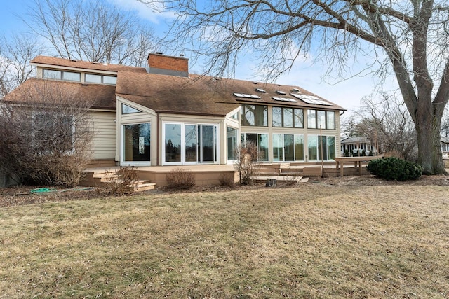 rear view of house with a sunroom and a lawn