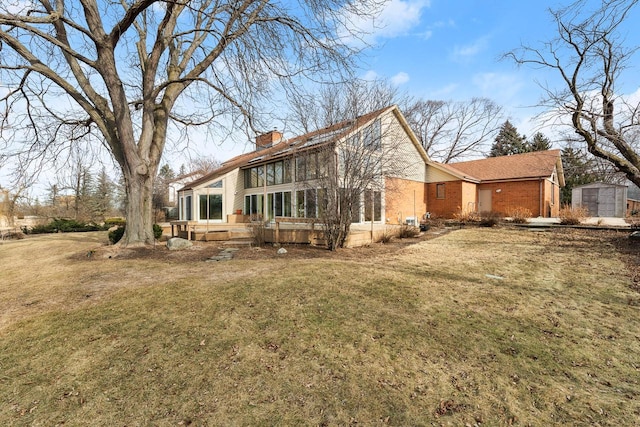 back of house featuring a yard and a storage unit