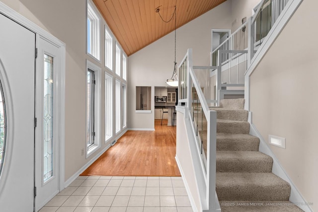 tiled foyer with high vaulted ceiling and wooden ceiling